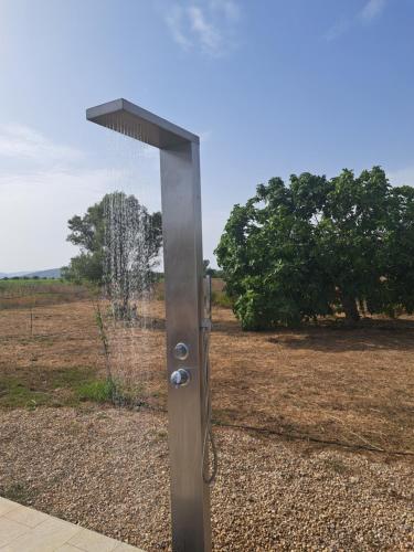 a metal pole with a shower in a field at pura natura Alghero in Alghero