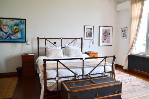 a bedroom with a metal bed with white pillows at B&B Petit-Hallet in Hannut