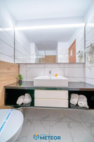 a bathroom with a sink and a toilet at Hotel Meteor in Jupiter