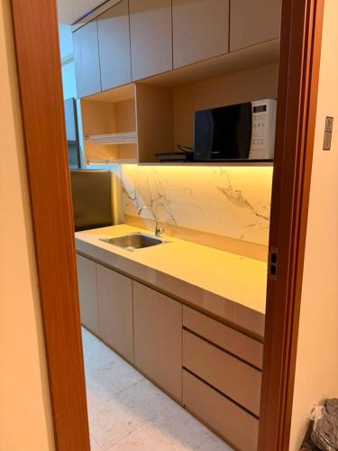 a kitchen with a sink and a microwave at Smart Studio - BResidences ICE BSD in Tjilandak