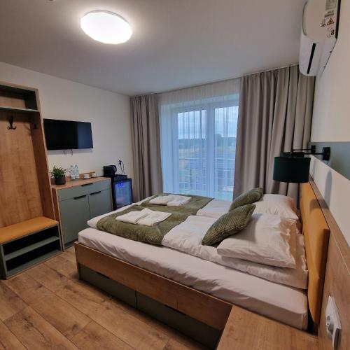 a bedroom with a large bed with a large window at Willa Na Białej in Ziajki