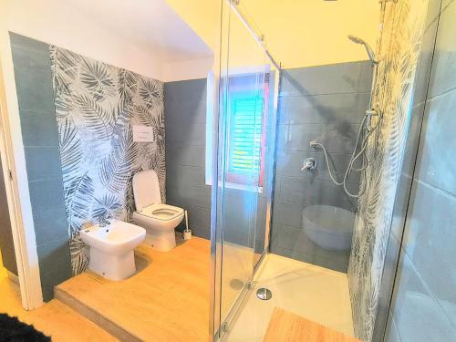 a bathroom with a toilet and a glass shower at Il Ligustro Terrace in Casal Sottano
