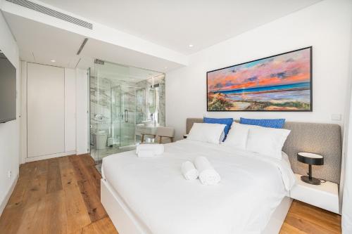 a white bedroom with a large bed and a shower at Vilamoura 4-Bedroom Penthouse with Jacuzzi in Vilamoura
