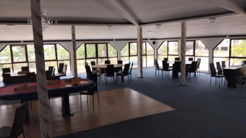 a dining room with tables and chairs and windows at Hotel Dona in Mamaia