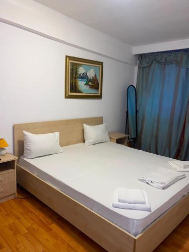a bedroom with a large bed with white sheets at Hotel Dona in Mamaia