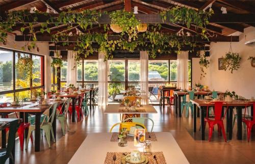 a restaurant with tables and chairs and plants hanging from the ceilings at Rizzu Marina Hotel in Balneário Camboriú