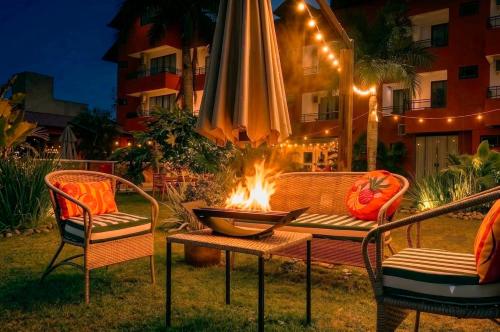 a table and chairs with a fire pit in front of a building at Rizzu Marina Hotel in Balneário Camboriú