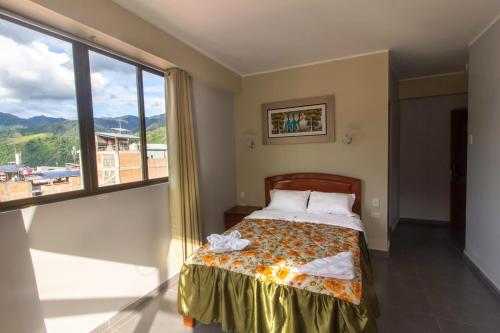 a bedroom with a bed and a large window at Hotel Luxor Selva in La Merced