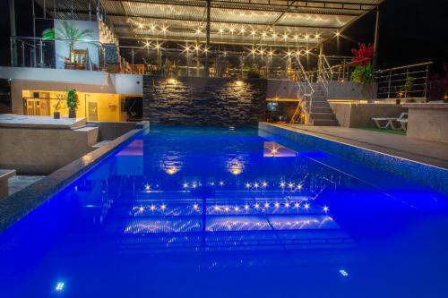 a pool with lights in a hotel at night at Hotel Luxor Selva in La Merced