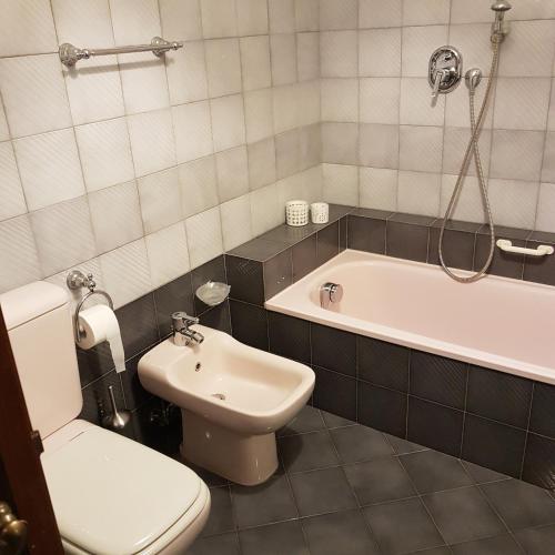 a bathroom with a toilet and a tub and a sink at Residenza al Volto in Venice