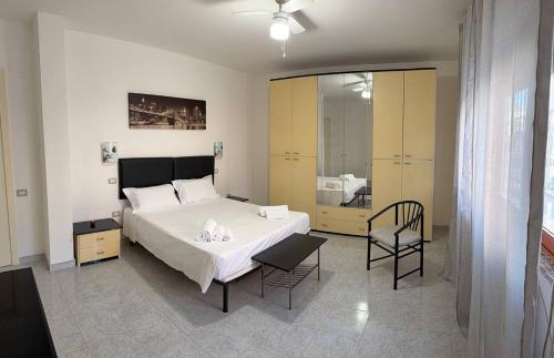 a bedroom with a large bed and a chair at Ro's House in Assemini