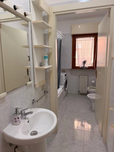 a bathroom with a sink and a toilet at Ro's House in Assemini