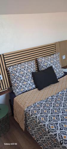 a bed with blue and white sheets and pillows at Cap Esterel vue Mer in Agay - Saint Raphael
