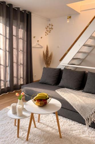 a living room with a couch and a table at Joli triplex proche Colmar in Sainte-Croix-en-Plaine