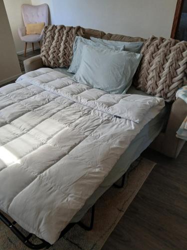 a bed with white sheets and pillows on it at 5 blocks from the hospital! in Bismarck