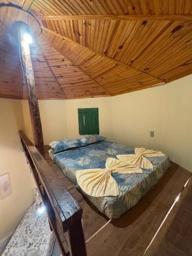 a bedroom with two beds and a wooden ceiling at Chalé Raio De Sol in Vale do Capao