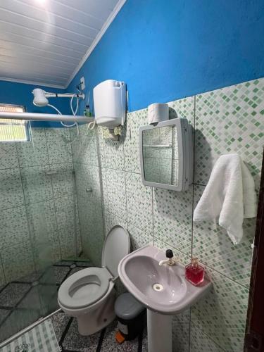 a small bathroom with a toilet and a sink at Chalé Raio De Sol in Vale do Capao