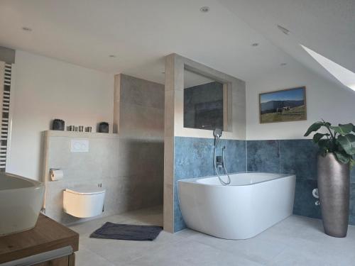 a bathroom with a white tub and a sink at Ferienwohnung Unterallgäu in Markt Rettenbach