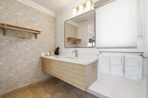 a bathroom with a sink and a mirror at Sunset Motel in Santa Barbara