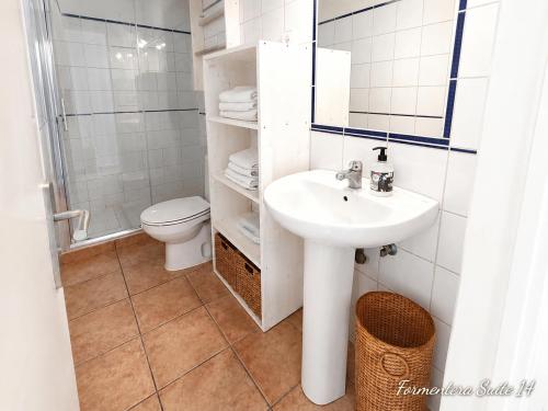 a white bathroom with a sink and a toilet at Formentera suite 14 in Es Pujols