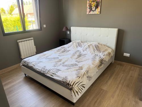 a bedroom with a bed with a white bed frame at Normandy lodges in Le Dézert