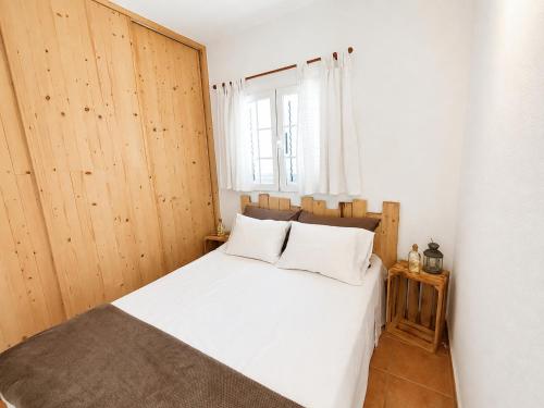 a bedroom with a white bed and a window at Formentera suite 14 in Es Pujols