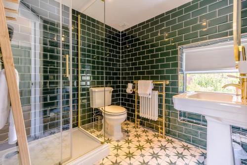 a green tiled bathroom with a toilet and a sink at 4 Bed in East Rudham oc-t28312 in East Rudham