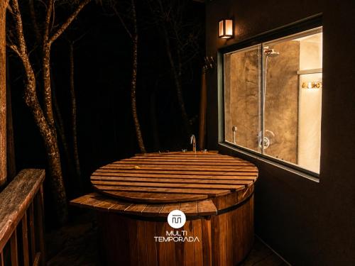 a bathroom with a wooden tub with a sink at Refugio Marincek - Gonçalves - MG in Gonçalves