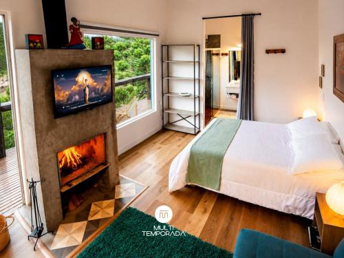 a bedroom with a bed and a fireplace at Refugio Marincek - Gonçalves - MG in Gonçalves