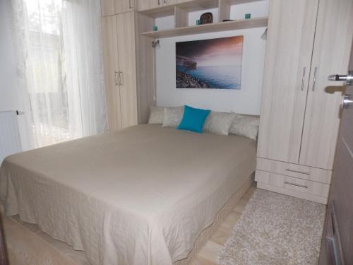ザマールディにあるNemorosa Apartmanの小さなベッドルーム(ベッド1台、キャビネット付)