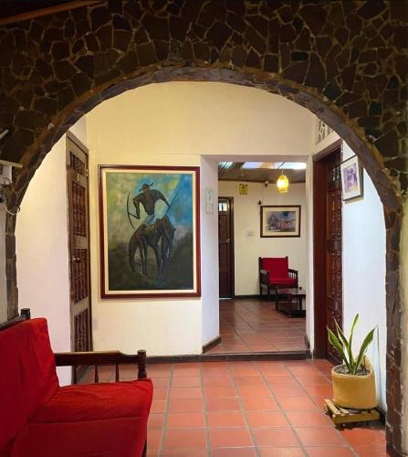 a living room with a red couch and a painting on the wall at Hotel Cacique in Socorro