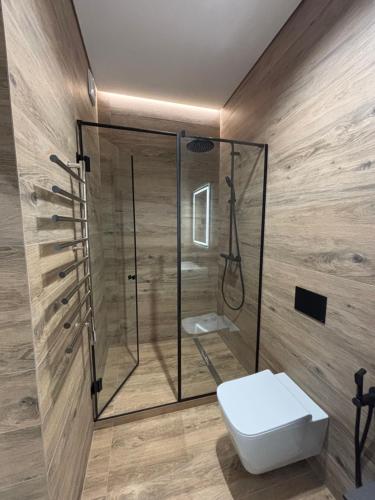 a bathroom with a glass shower and a toilet at Bavaro apartments 8 in Ivano-Frankivsk