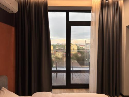 a bedroom with a window with a view of a balcony at Bavaro apartments 8 in Ivano-Frankivsk