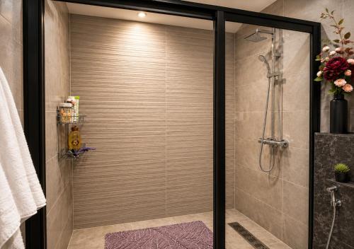 a shower with a glass door in a bathroom at Le Jardin Secret - Pool View Elegance in Mohammedia