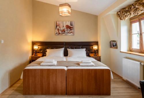 a bedroom with a bed with two towels on it at Kazimierz Secret in Krakow
