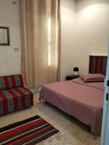 a bedroom with a bed and a chair in it at Relax in Tunis