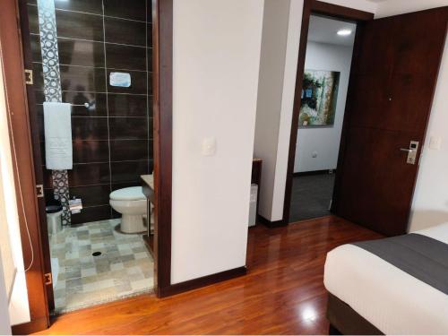 a bedroom with a bathroom with a toilet and a shower at Hotel macao colombia in Bogotá