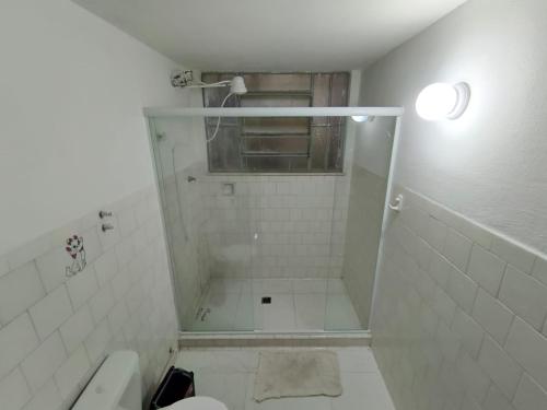 a white bathroom with a shower and a toilet at Apartamento na RETA de Teresópolis in Teresópolis