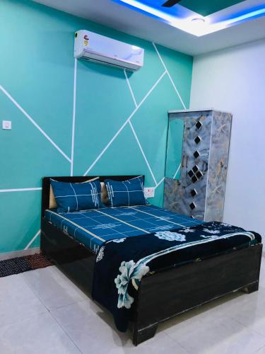 a bedroom with a bed with a blue wall at Balaji Lodge in Laling
