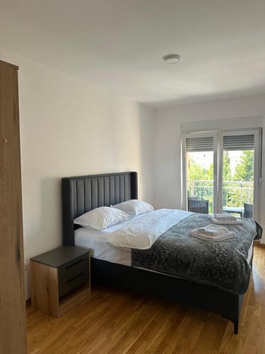 a bedroom with a large bed and a window at Apartman VUKOVIĆ in Žabljak