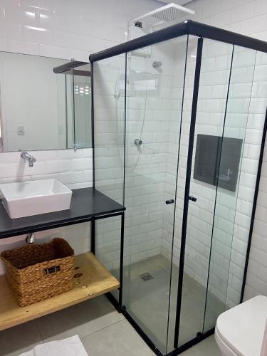 a bathroom with a glass shower and a sink at Requinte Hotel in São Paulo
