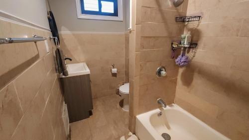 a bathroom with a tub and a toilet and a sink at Vintage Home Vibe in Jersey City