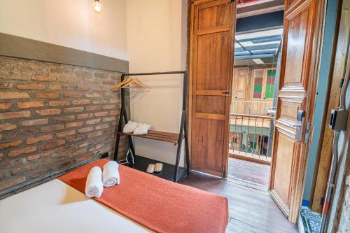 a room with a red rug and a brick wall at Delgadillo Boutique Hotel by Socialtel in Bogotá
