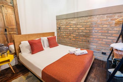 a bedroom with a bed and a brick wall at Delgadillo Boutique Hotel by Socialtel in Bogotá