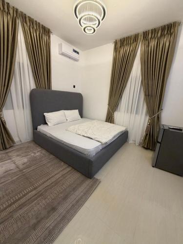 a bed in a room with curtains and a television at Was Homes in Abuja