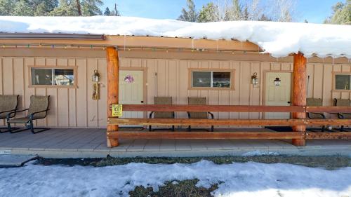 a cabin with snow on the roof and a bench at Arrowhead 18 in Red River