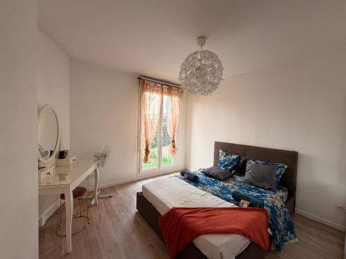 a bedroom with a bed and a desk and a window at Cocon avec petit jardin centre Bondy in Bondy