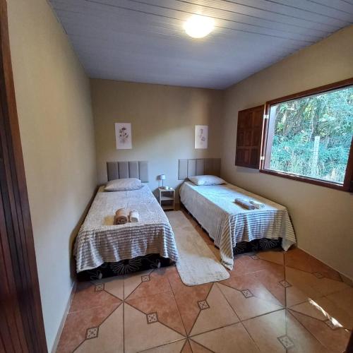 a bedroom with two beds and a window at Pousada Santa Rita in Ouro Preto