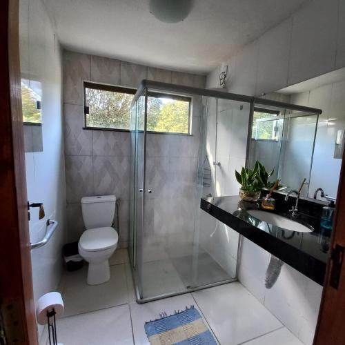 a bathroom with a shower and a toilet and a sink at Pousada Santa Rita in Ouro Preto