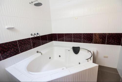 a bath tub in a bathroom with red and white tiles at Hotel Prince Selva Central in La Merced